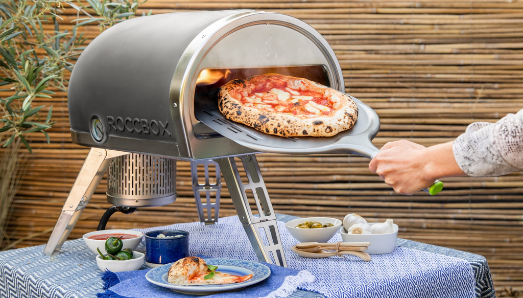 Gozney Roccbox Pizza oven met pizza op pizzaschep makkelijk en goedkoop huren bij BIYU