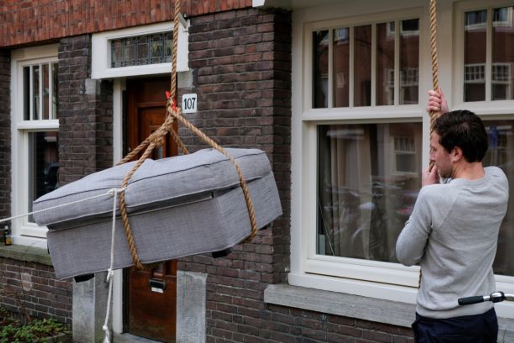 Rope and Bloc Pulley Hand Hoist whilst a couch is being hoisted during a move in Amsterdam. Affordable rental with BIYU.